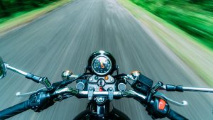 The handlebars of a motorcycle on a scenic open road, symbolizing the freedom and adventure of a road trip.