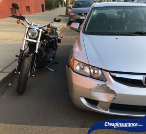 A car with front bumper damage parked next to a motorcycle, symbolizing how a car driving record can impact a motorcycle license.